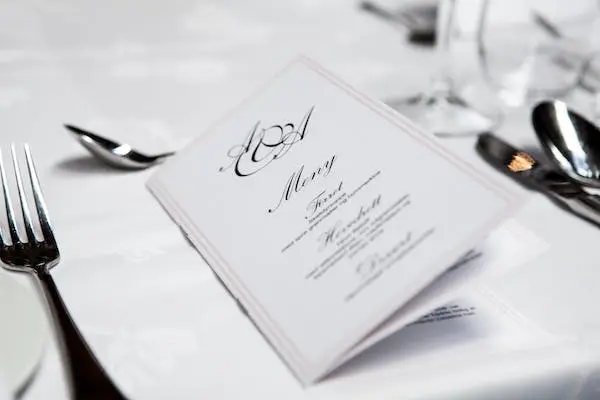 white menu on the table with fork and spoon nearby